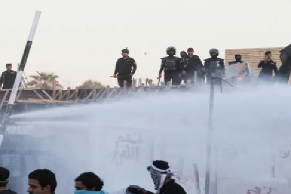 Iraqi security forces deploy a water cannon as protesters gather near the Swedish embassy in the capital Baghdad