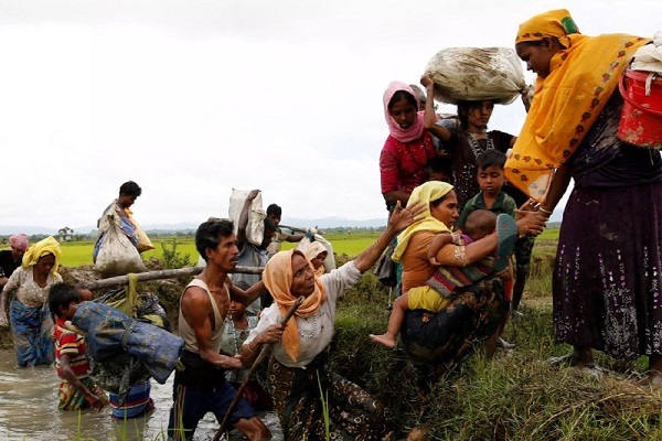 Rohingya refugees help each other after crossing the Bangladesh-Myanmar border. (Photo by Reuters) Ethnic cleansing and Muslims