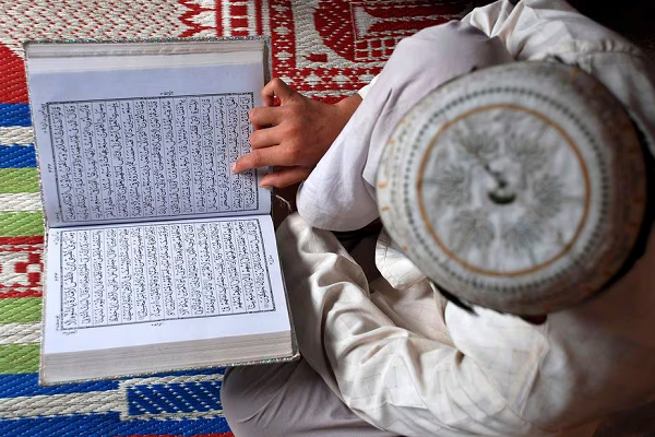 A Muslim boy reads the Quran at a madrasa or religious school on the first day of the holy month of Ramadan in the northern Indian city of Mathura August 23, 2009 (Reuters)
