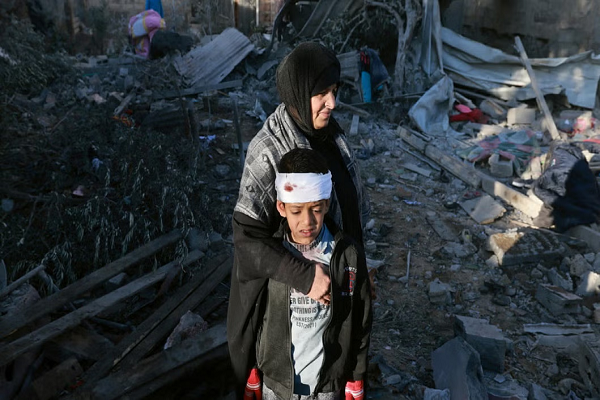 A Palestinian woman and her child seen in the rubble of Gaza after Israeli bombings