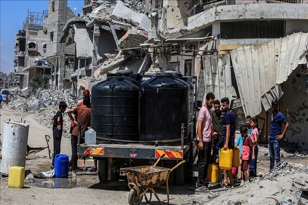 Palestinians queue for hours under the burning sun to fill their bottles and jerrycans with drinking water amid an Israeli war on Gaza