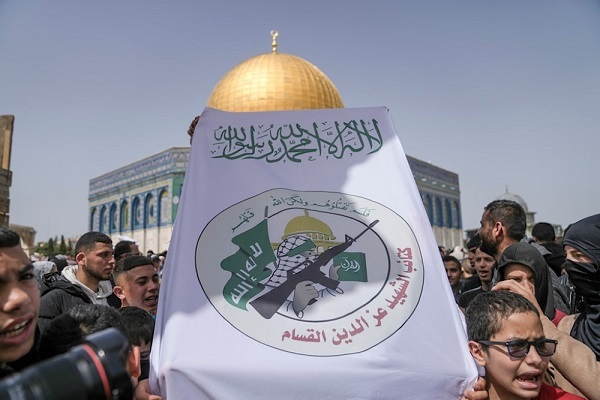 Demonstators carry a flag of the al-Qassam Brigades, the military wing of the Palestinian Hamas resistance movement