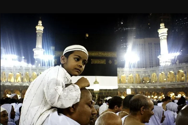 A child visiting the Grand Mosque in Mecca with his father.