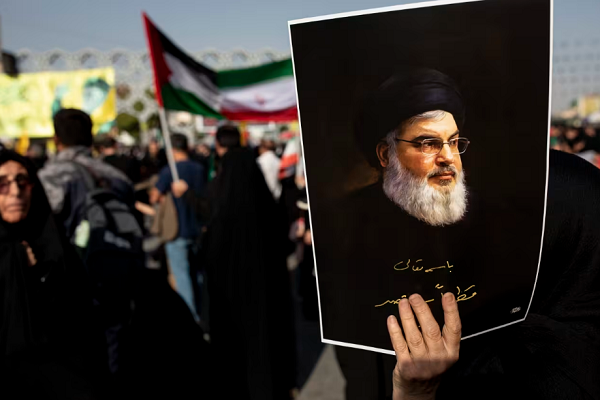 An Iranian carrying a photo of former Hezbollah secretary general Sayed Hassan Nasrallah