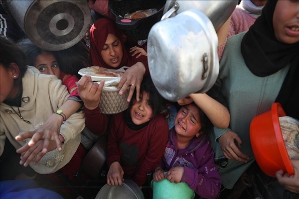 Palestinians, including children, who are struggling with hunger wait in line to receive meals distributed by charities while the humanitarian crisis is increasing as Israel continues to attack the Gaza Strip by breaking the ceasefire and keeping the borders closed in Beit Lahia, Gaza, on March 22, 2025.