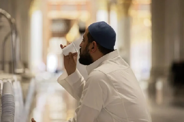 A worshipper drinking Zamzam water at the Prophet's Mosque in Medina