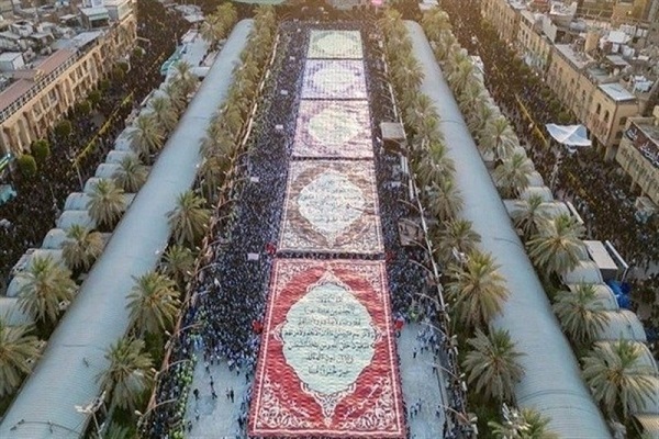 Arbaeen pilgrims carrying large banners displaying verses of Quran