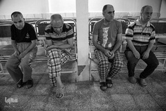 محمدحسن به همراه محمود(بیمار ۵۱ ساله سندورم دان) جان محمد (بیمار ۵۲ ساله اعصاب و روان) صفر (بیمار ۵۳ ساله عقب مانده ذهنی) در بخش خودشان بر روی نیمکت آهنی نشسته اند.