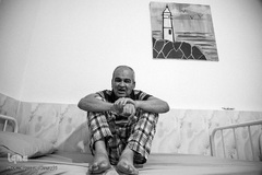 محمدحسن بر روی تخت خود نشسته و ساعات روز خود را به استراحت می پردازد