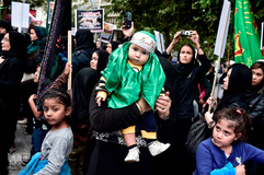 یک زن دارای یک لباس مذهبی؛ مسلمانان شیعه در میدان سنتاگما در آتن نماز ظهر عاشورا را اقامه می کنند