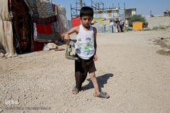 متین کودک بیمار که به همراه خانواده مستاجر خود در کانکس های اهدایی در محله زعفران سرپل ذهاب زندگی میکند 