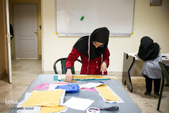 میثاق بختیاری، در حال یادگیری خیاطی است.