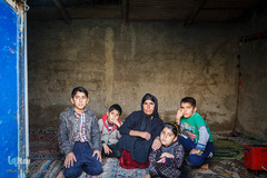 مینا احمدی به همراه همسر و چهار فرزند خود (شاهرخ ۱۴ساله، شادمهر۱۲ساله، فرهاد ۷ ساله و بهاره ۶ساله) ساکن روستای دره‌بوری در ۲۰ کیلومتری شهرستان لالی هستند. وی می‌گوید: «همسرم اعتیاد دارد و  بیشتر اوقات خانه نیست، زمانی هم که می‌آید برای مواد مرا را کتک می‌زند». به گفته مددکار کمیته امداد امام، هفته گذشته همسرش به علت نداشتن مواد، مینا را کتک زده و خانه‌اش را به آتش کشیده است. 